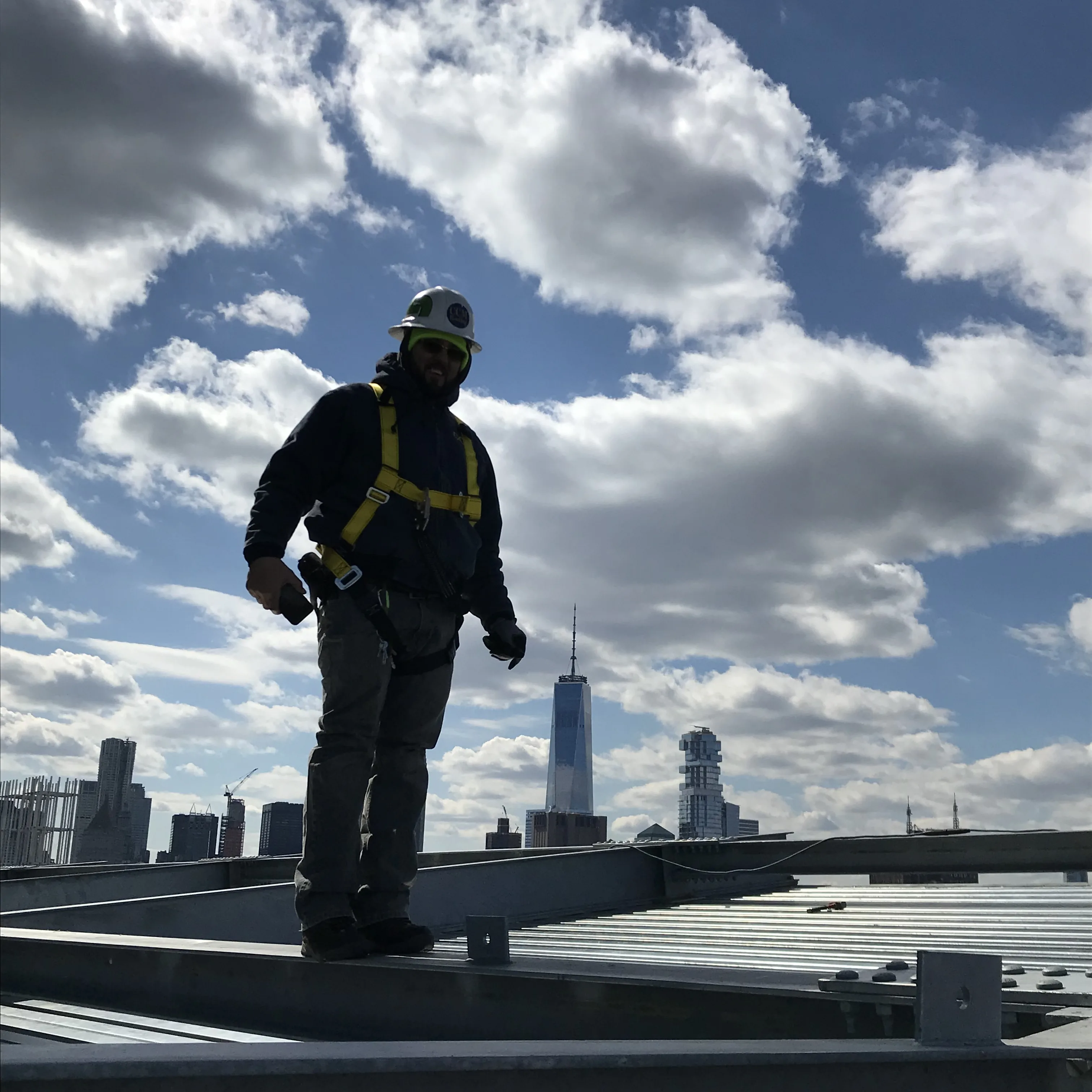 CCM Roofing crew member on The Public Hotel rooftop with downtown Manhattan skyline