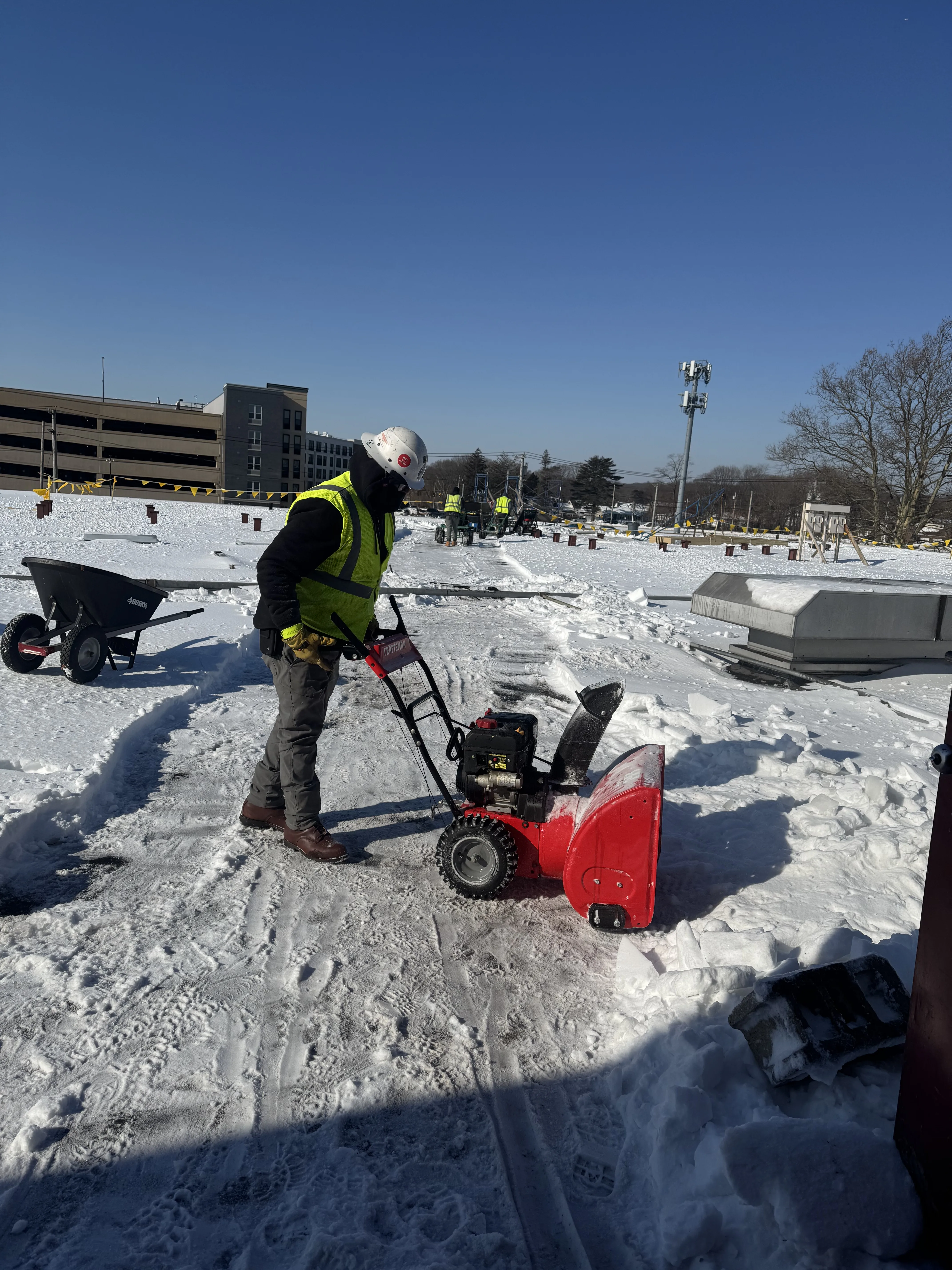 CCM Roofing crew removing snow from a commercial rooftop